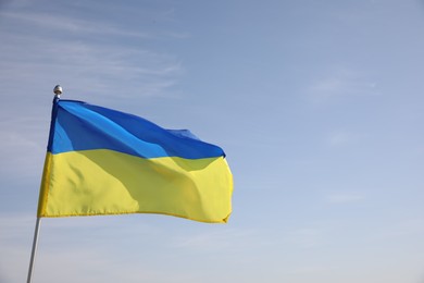 Photo of National flag of Ukraine against blue sky. Space for text