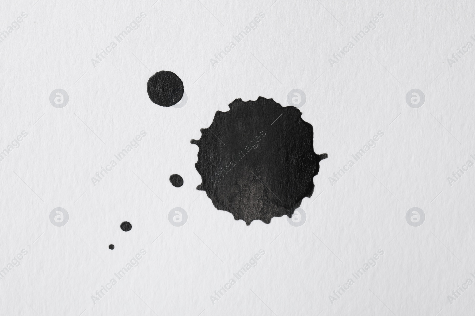 Photo of Blots of black ink on white background, flat lay