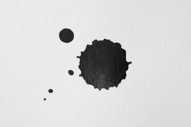 Blots of black ink on white background, flat lay