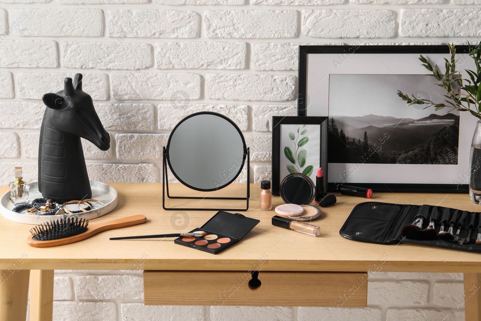 Photo of Dressing table with mirror, makeup products and accessories in room