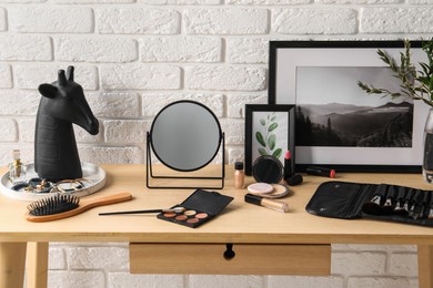 Dressing table with mirror, makeup products and accessories in room