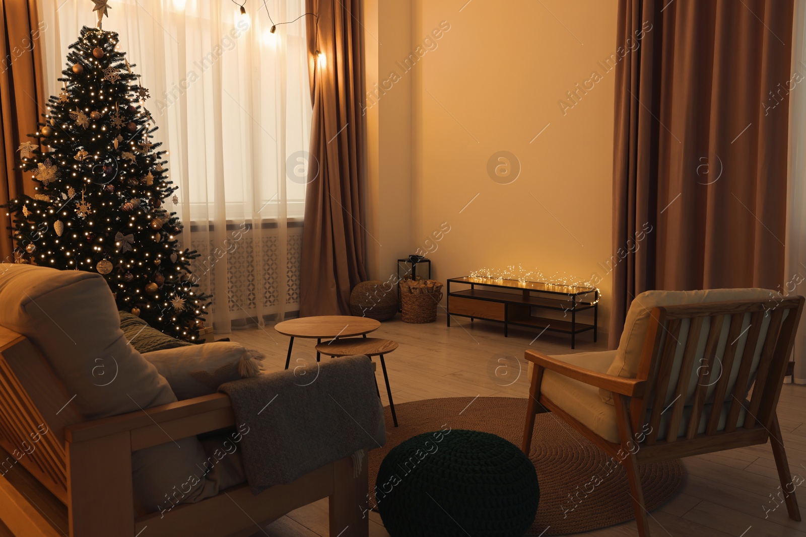 Photo of Tv area with cabinet, comfortable sofa, armchair and coffee table near Christmas tree in room