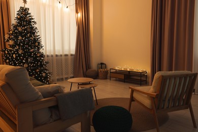 Photo of Tv area with cabinet, comfortable sofa, armchair and coffee table near Christmas tree in room