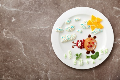 Photo of Plate with pancakes in form of ladybug on grey background. Creative breakfast ideas for kids