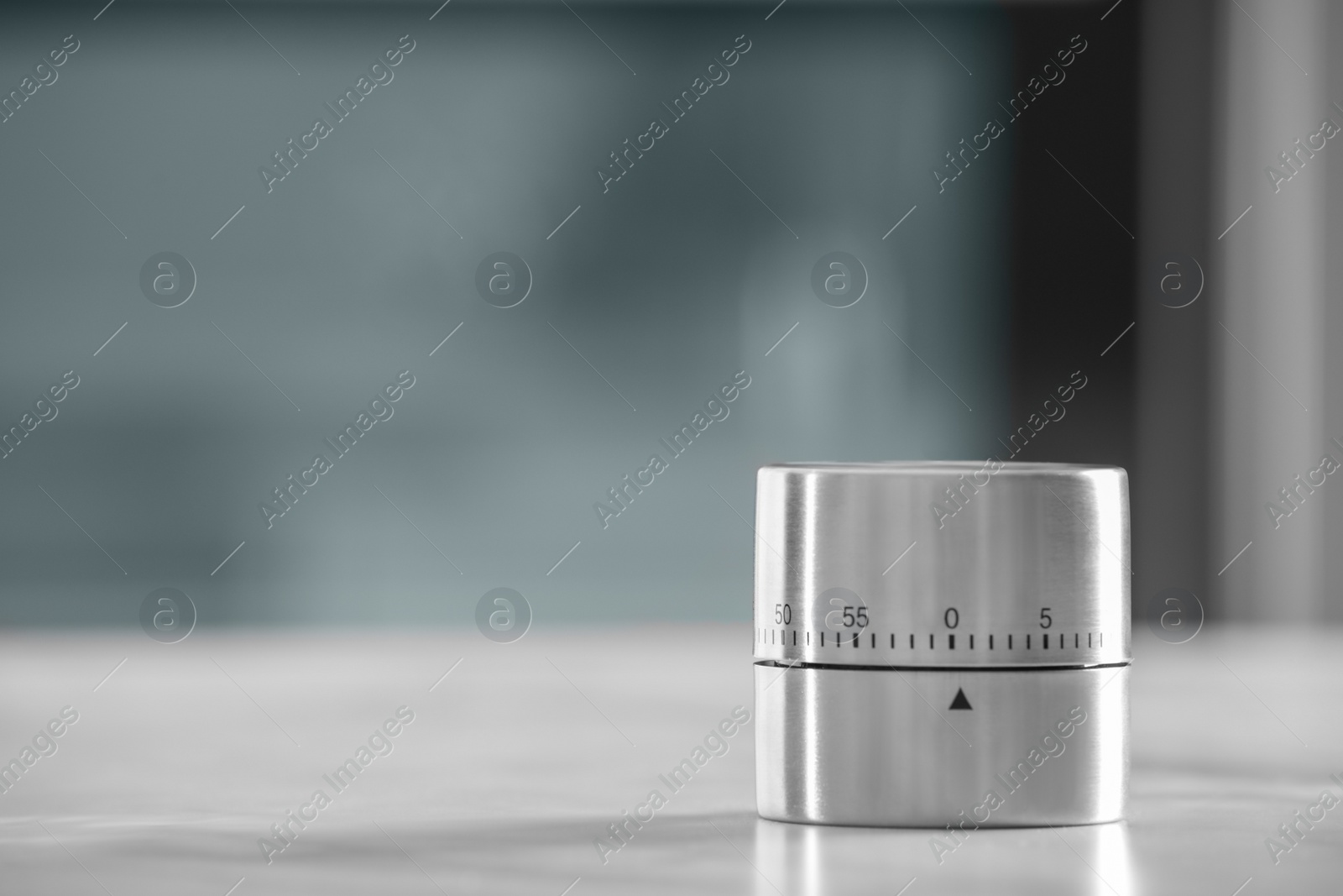 Photo of Kitchen timer on light grey table against blurred background. Space for text