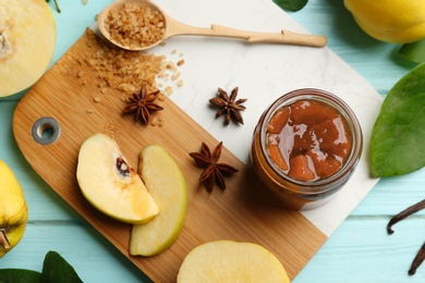 Photo of Composition with delicious quince jam and fruits on light blue wooden table, flat lay