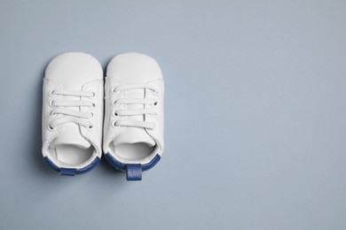 Photo of Cute baby shoes on grey background, flat lay. Space for text
