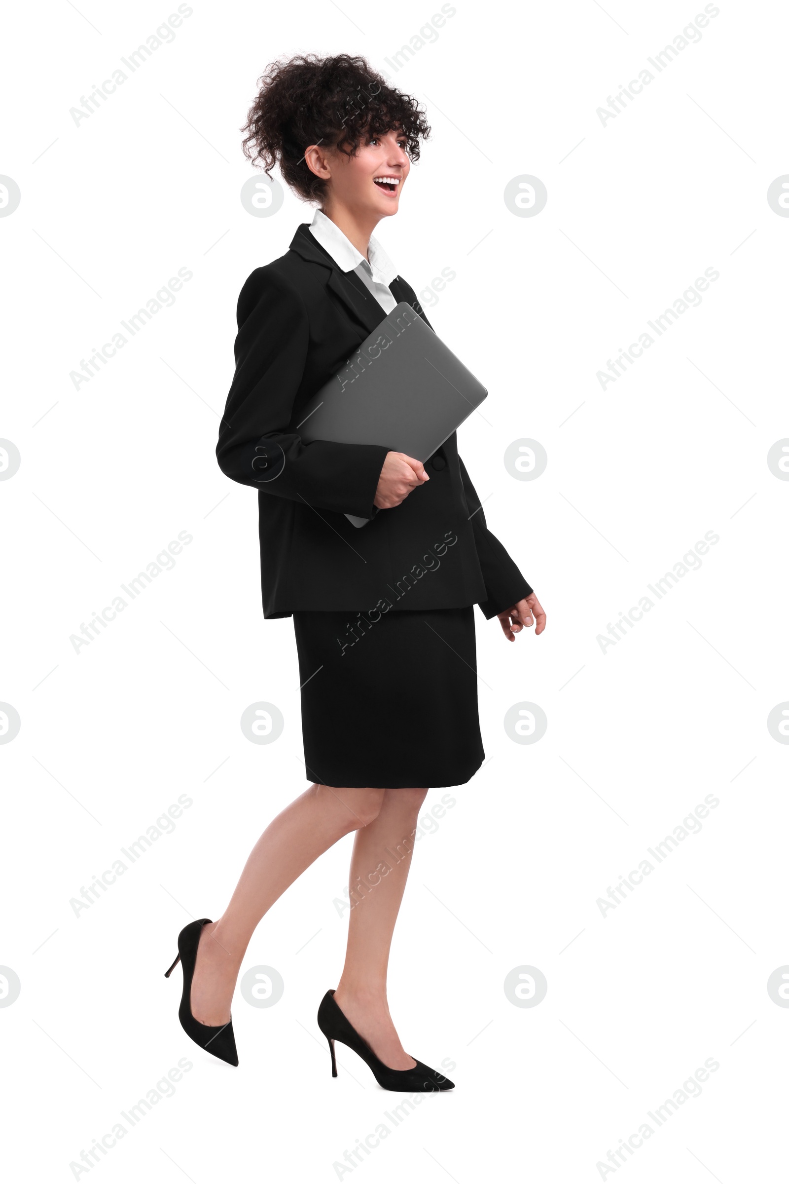 Photo of Beautiful businesswoman with laptop walking on white background