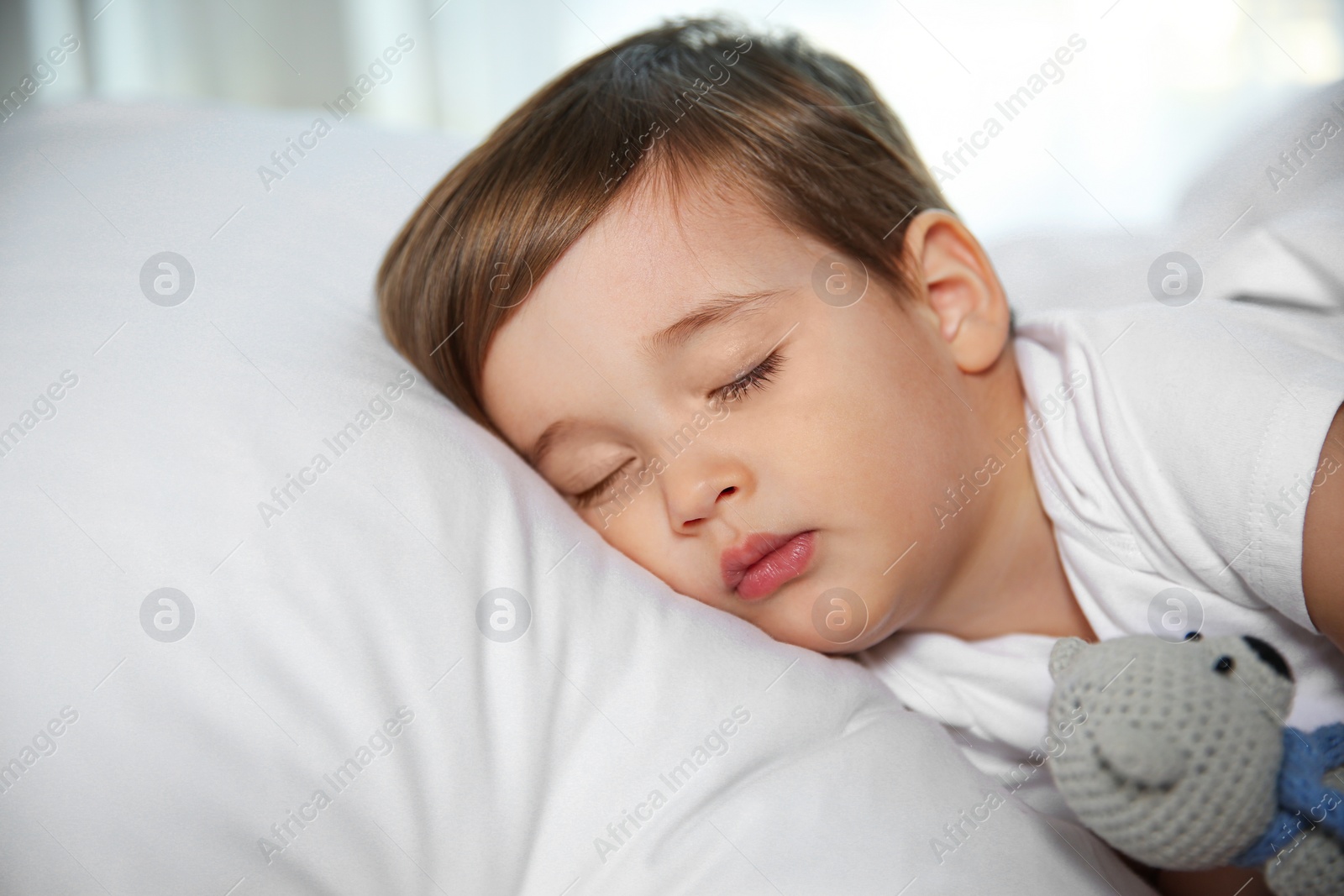 Photo of Cute little baby sleeping with toy at home. Bedtime