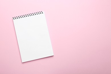 Photo of One notebook on pink background, top view. Space for text