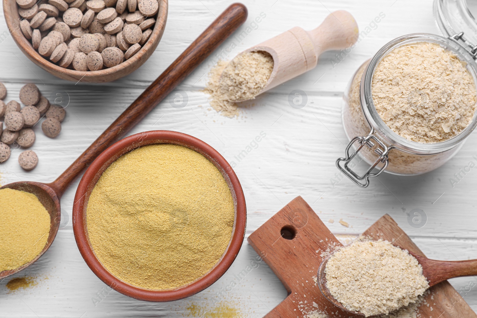 Photo of Flat lay composition with beer yeast powder, flakes and pills on white wooden table