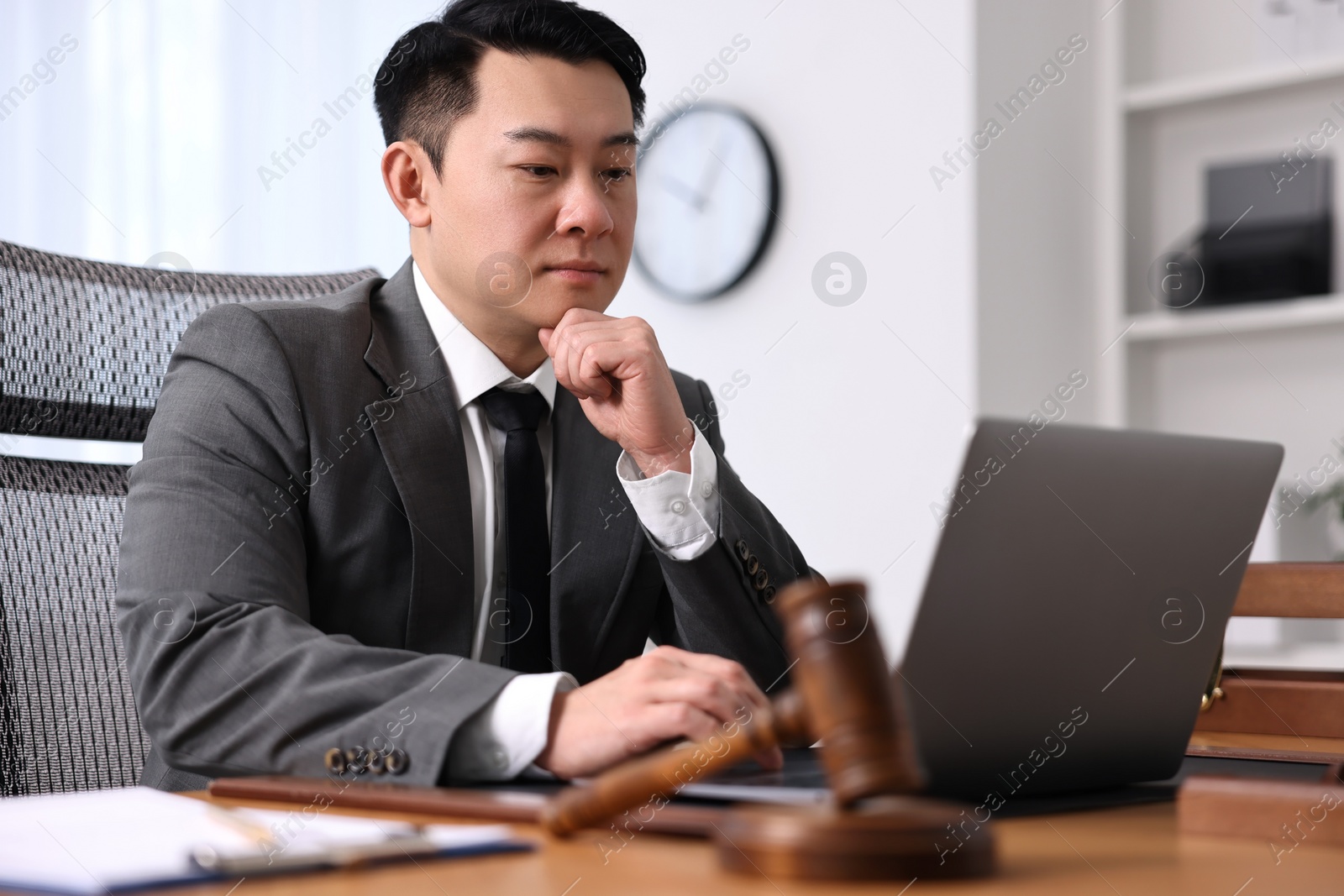 Photo of Notary working with laptop at wooden table in office