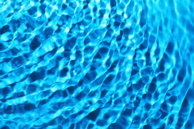 Image of Rippled surface of clear water on light blue background, closeup