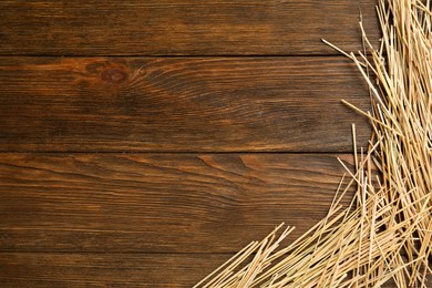 Dried hay on wooden background, flat lay. Space for text