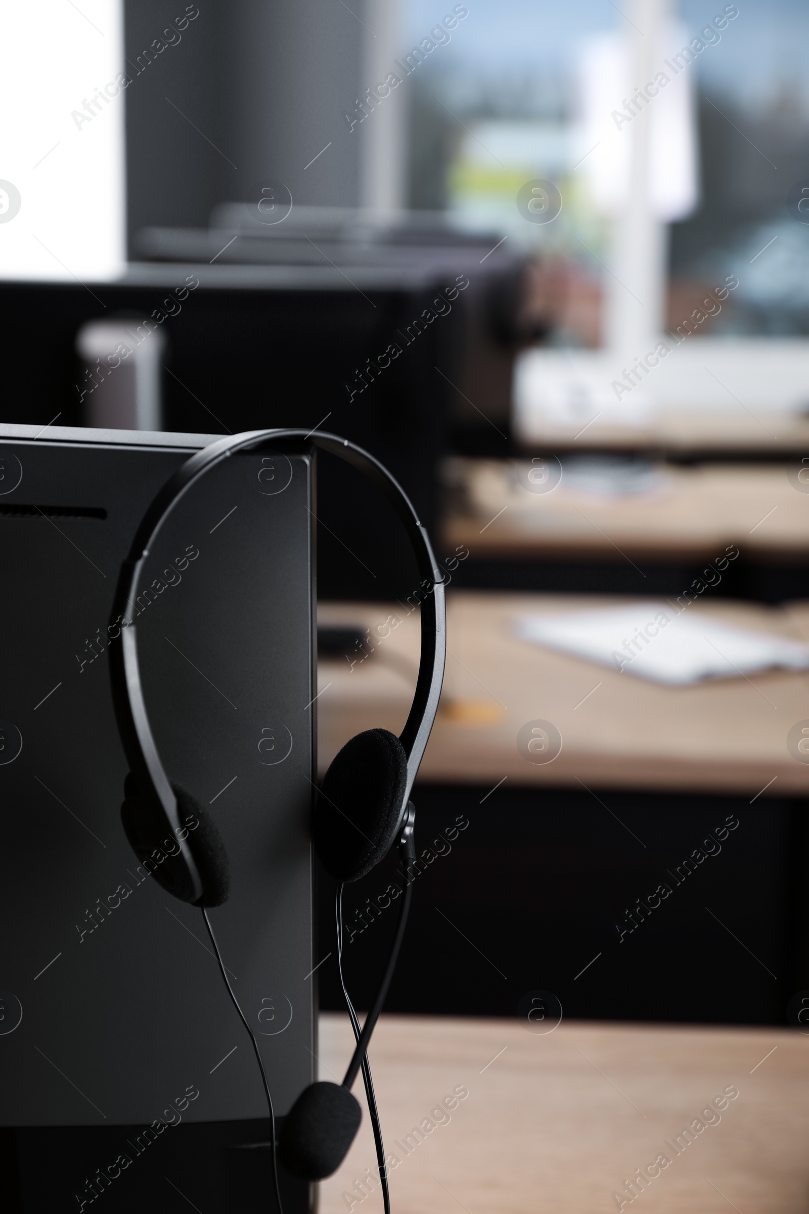 Photo of Modern computer with headset in office. Hotline service