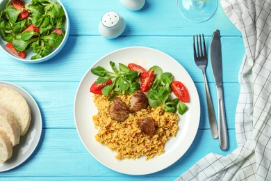 Photo of Delicious rice pilaf served on wooden table, top view