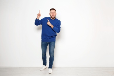 Photo of Full length portrait of emotional man against white wall. Space for text