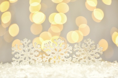 Photo of Beautiful decorative snowflakes against blurred festive lights