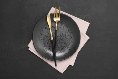 Photo of Elegant setting with shiny cutlery on black table, top view