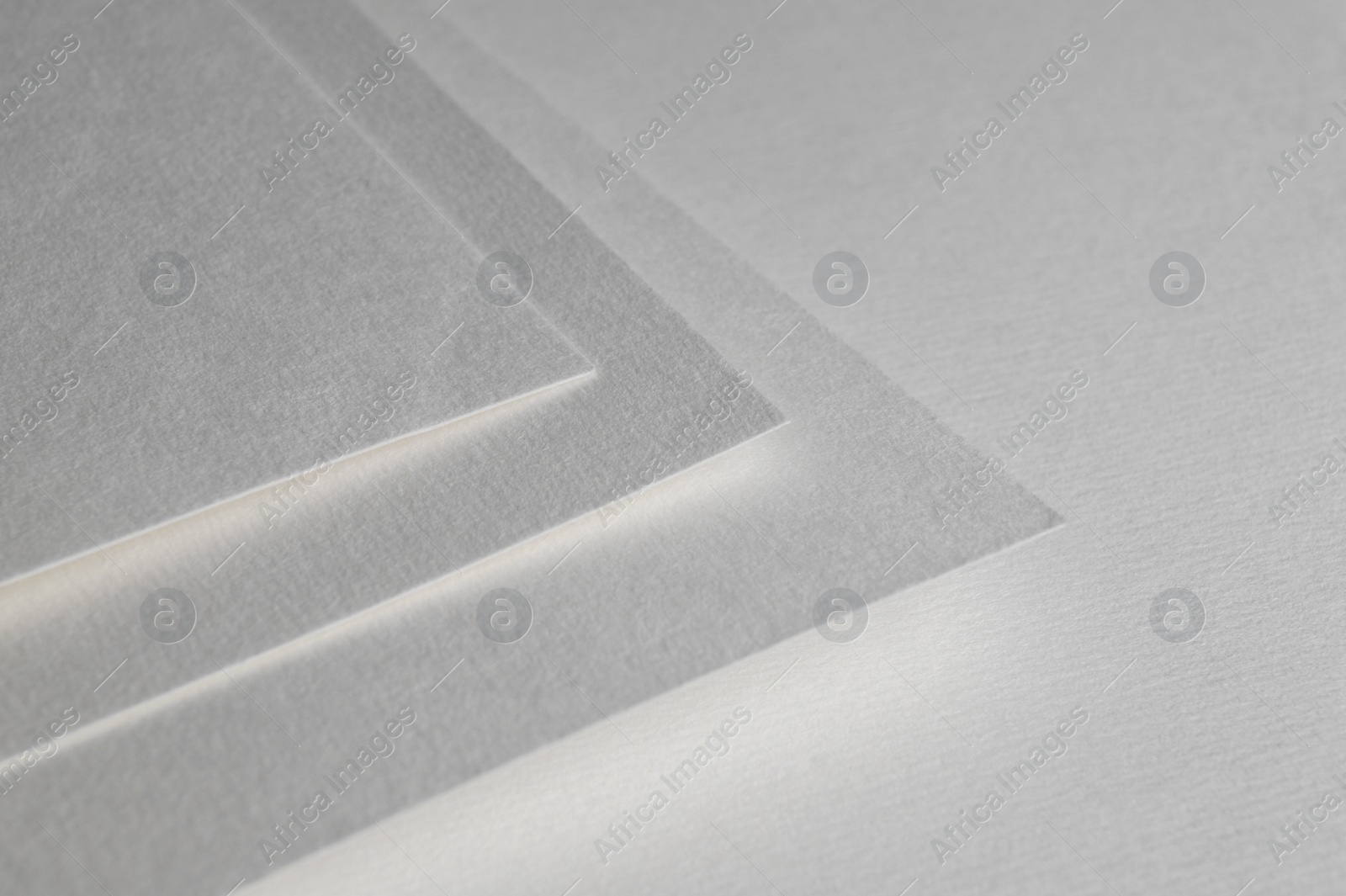 Photo of Blank watercolor paper sheets on white background, closeup