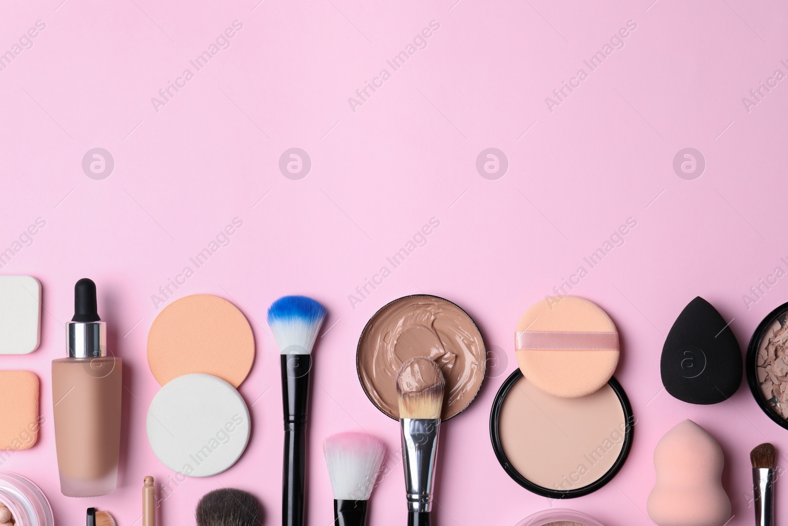 Photo of Flat lay composition with skin foundation, powder and beauty accessories on color background. Space for text