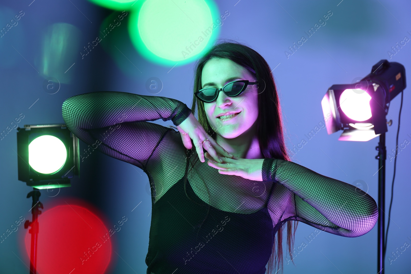 Photo of Portrait of beautiful young woman with sunglasses in photo studio