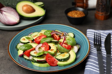 Photo of Tasty salad with cucumbers served on grey table
