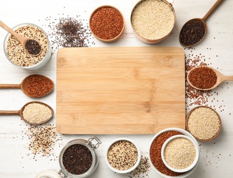 Photo of Different types of quinoa and empty wooden board with space for text on white wooden background