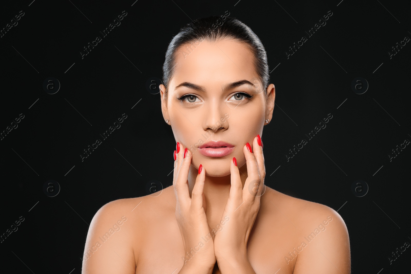 Photo of Portrait of beautiful young woman with bright manicure on black background. Nail polish trends