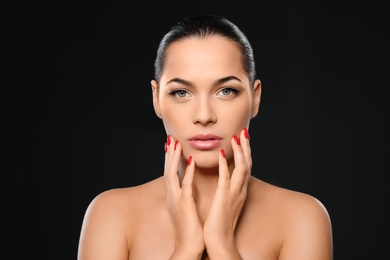 Portrait of beautiful young woman with bright manicure on black background. Nail polish trends