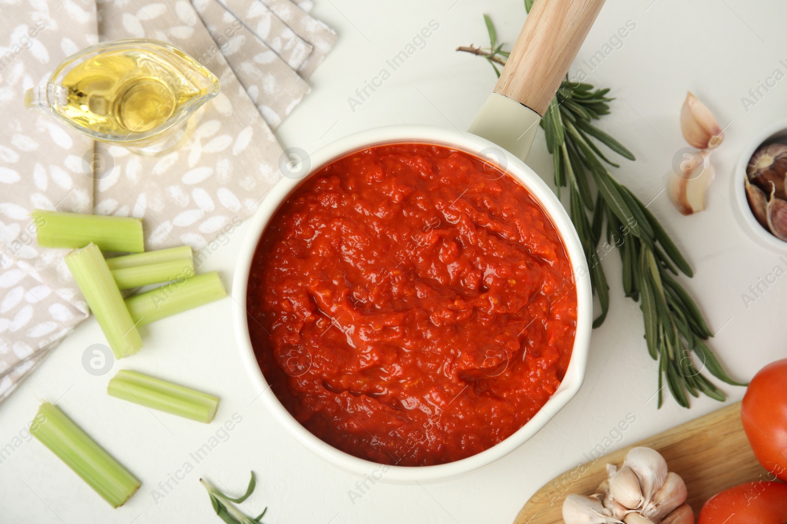 Photo of Flat lay composition with delicious tomato sauce in pan on white table