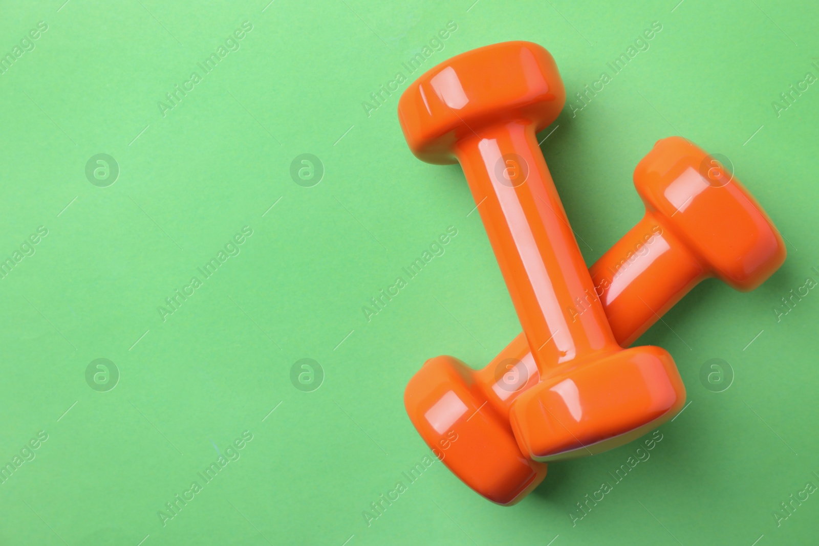 Photo of Bright dumbbells and space for text on color background, flat lay. Home fitness