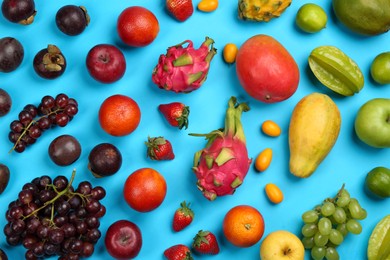 Assortment of fresh exotic fruits on light blue background, flat lay