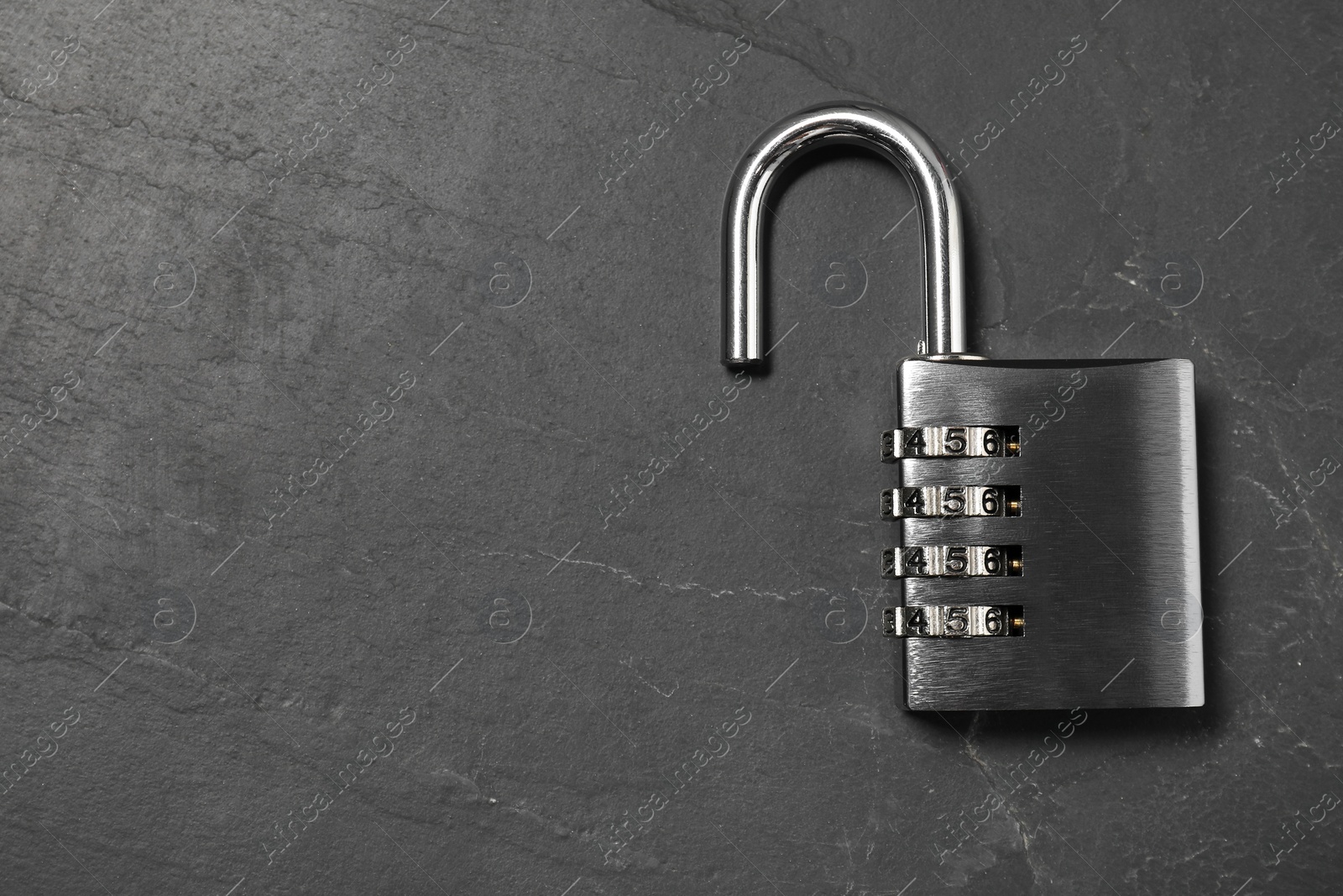 Photo of One steel combination padlock on black table, top view. Space for text