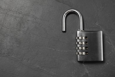 Photo of One steel combination padlock on black table, top view. Space for text