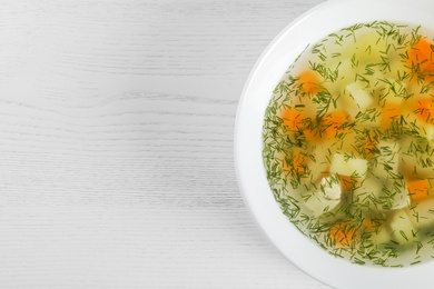 Photo of Bowl of fresh homemade soup to cure flu on wooden background, top view with space for text