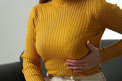 Photo of Mammology. Young woman doing breast self-examination at home, closeup