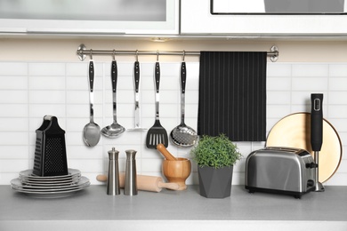 Photo of Different appliances, clean dishes and utensils on kitchen counter