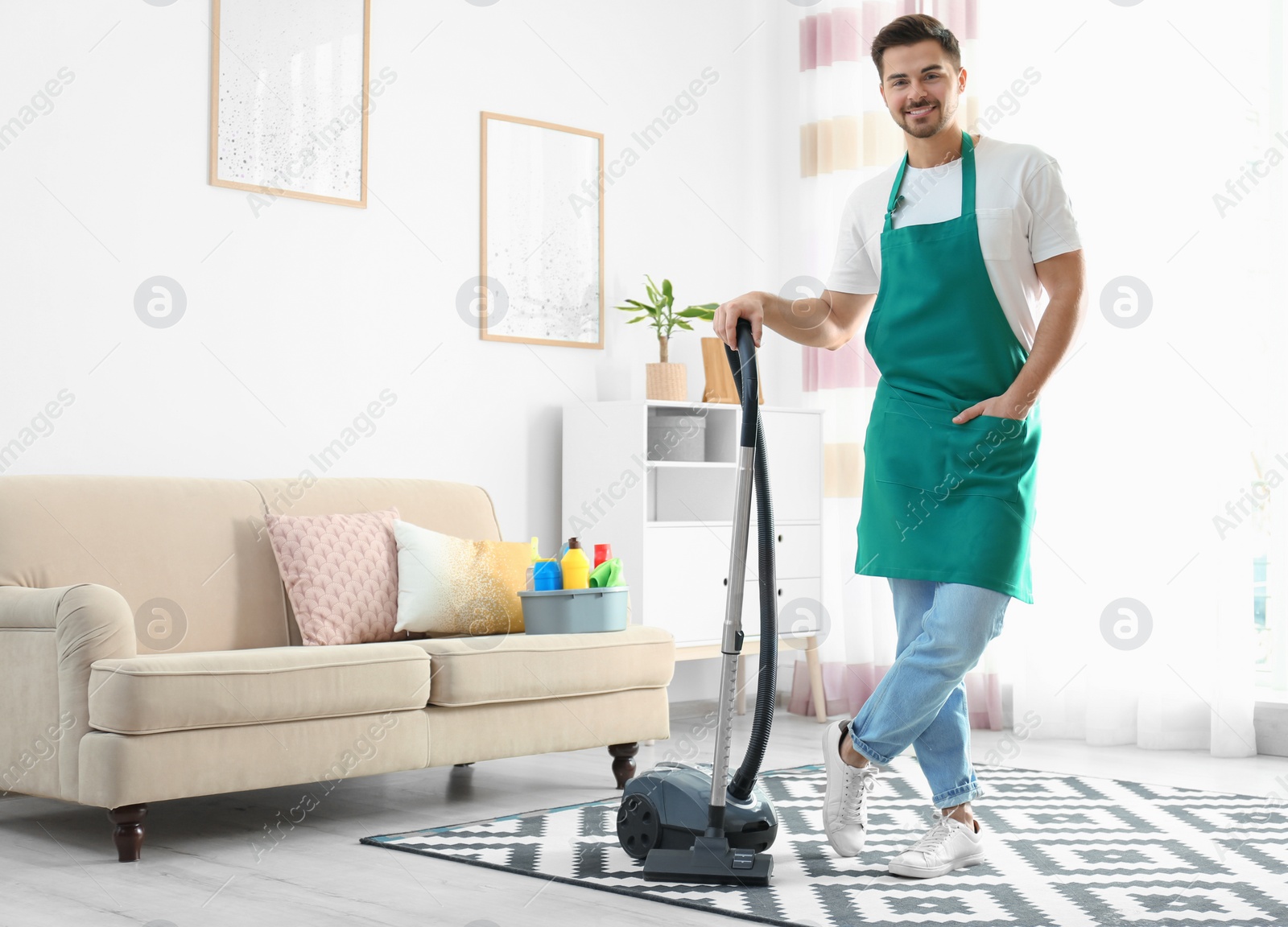 Photo of Portrait of janitor with vacuum cleaner in living room