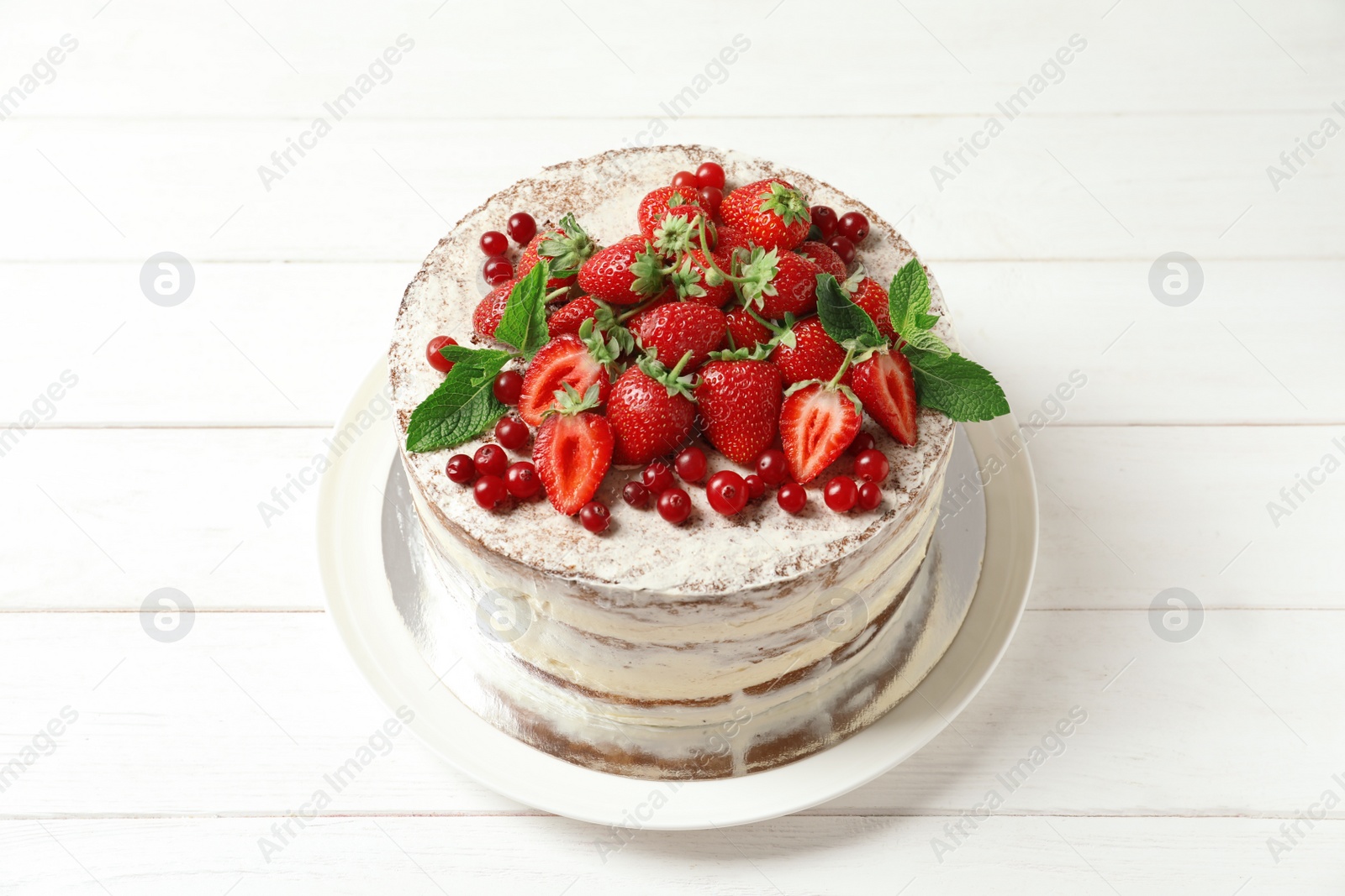 Photo of Delicious homemade cake with fresh berries on wooden table