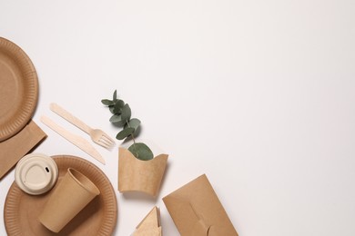 Photo of Eco friendly food packaging. Paper containers, tableware and eucalyptus branch on white background, flat lay. Space for text