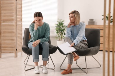 Photo of Professional psychotherapist working with patient in office