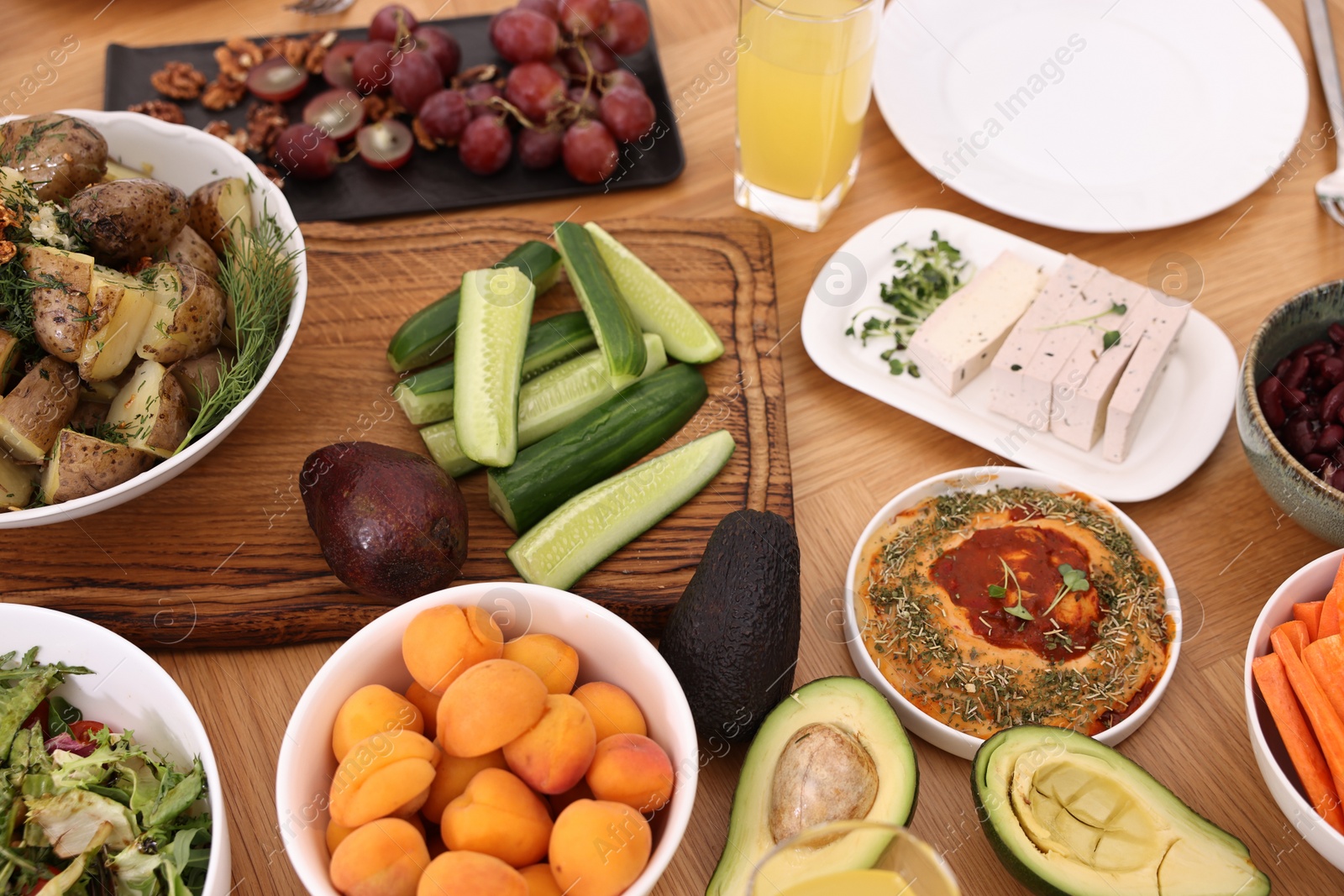 Photo of Healthy vegetarian food and glass of juice on wooden table