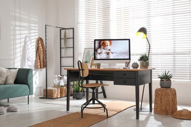 Photo of Stylish home office interior with sofa and comfortable workplace