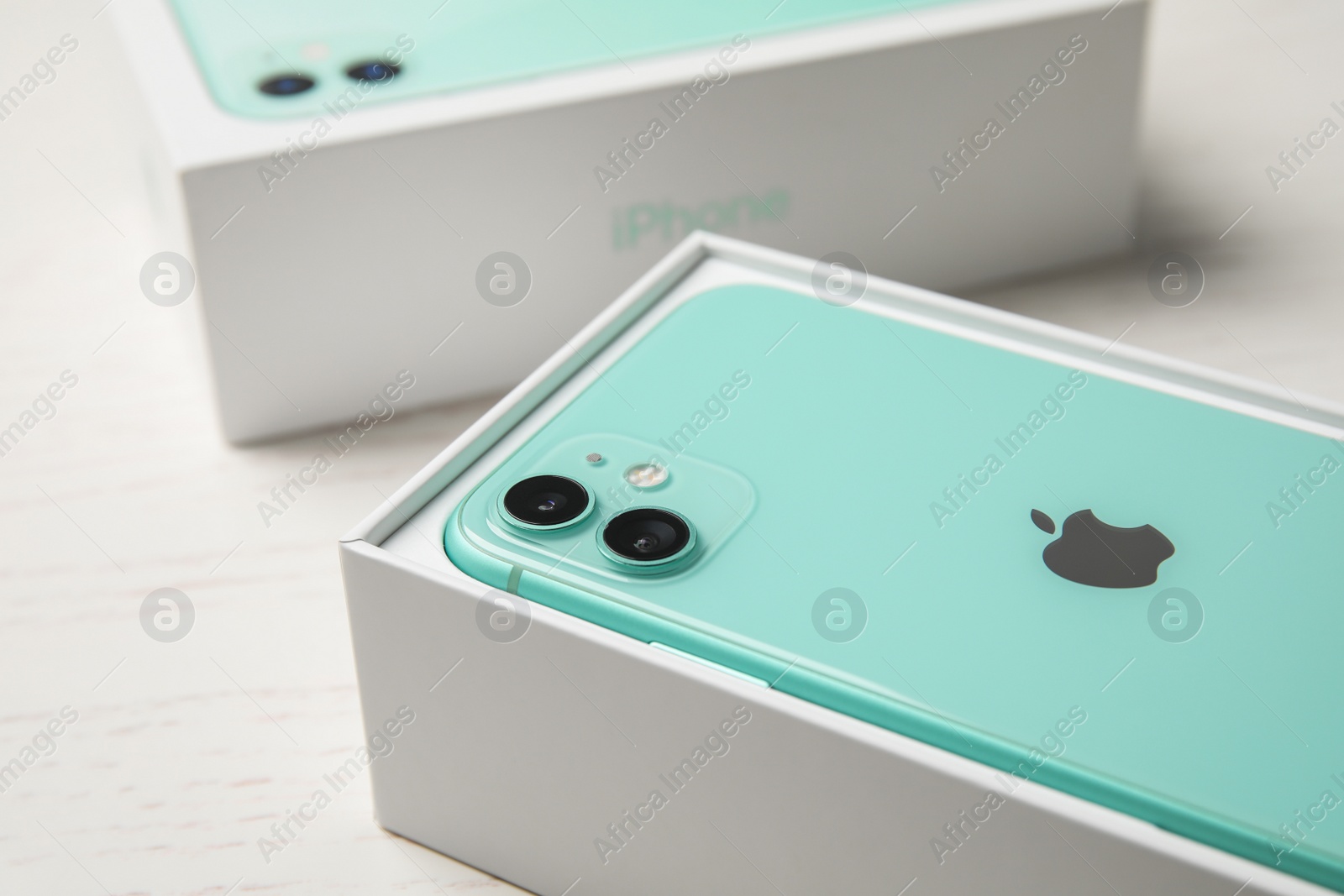 Photo of MYKOLAIV, UKRAINE - JULY 10, 2020: New modern Iphone 11 Green in original box on white table, closeup