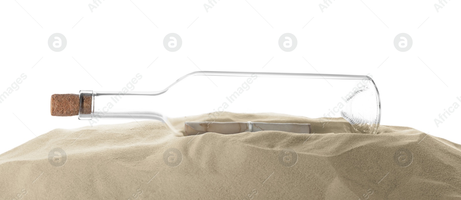 Photo of Corked glass bottle with rolled paper note on sand against white background