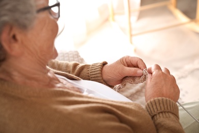 Elderly woman knitting at home, closeup. Creative hobby