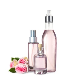 Photo of Bottles of essential oil and roses on white background