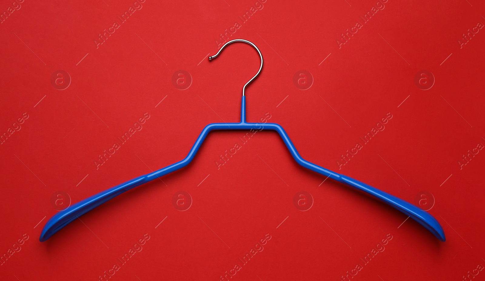 Photo of Empty clothes hanger on red background, top view