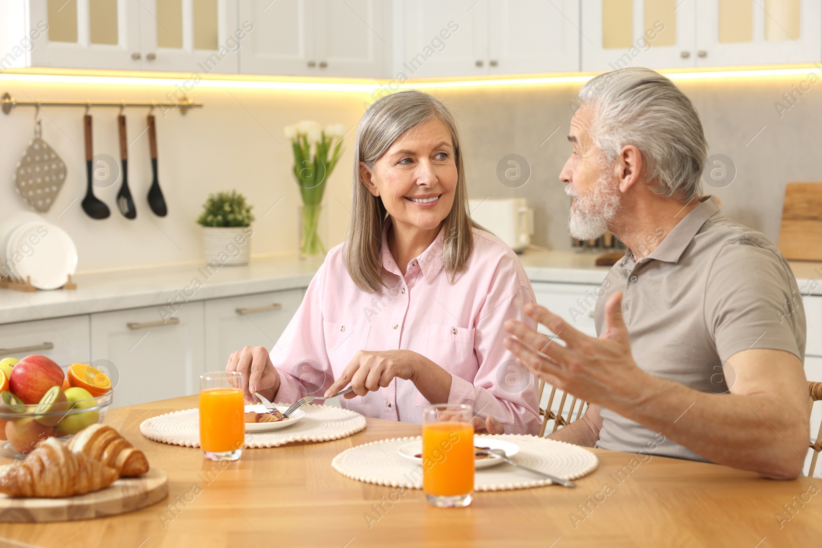 Photo of Happy senior couple having breakfast at home